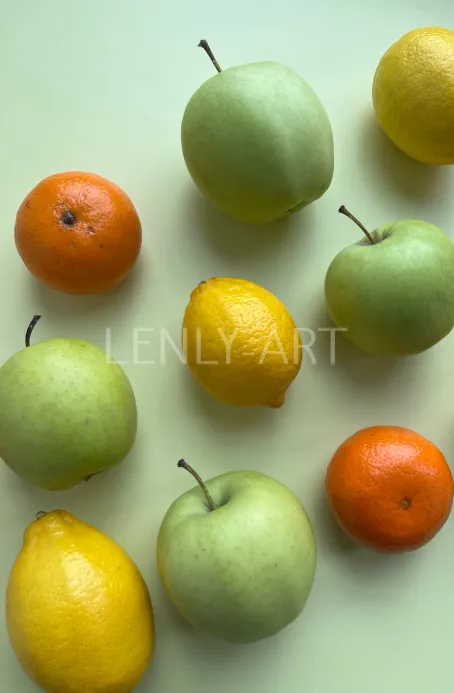 Яблоки лимоны мандарины на зеленом фоне